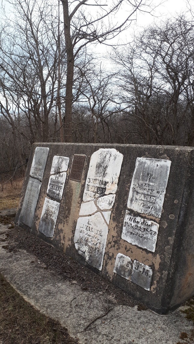 old cemetery stones in Orford Township mounted on concrete wall